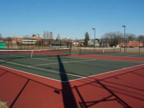 Green and Red Turf Enclosed Tennis Courts with Lights